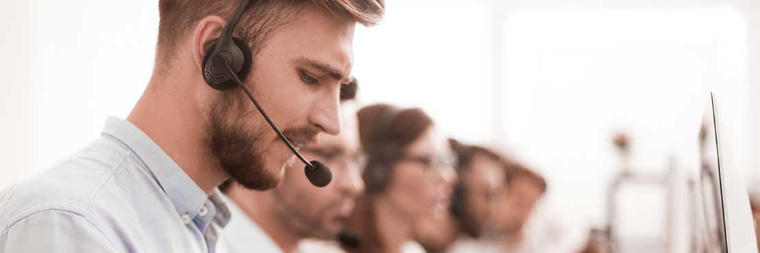 A man wearing a headset working in a call center