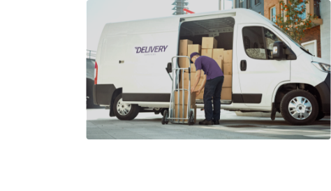 Delivery man loading boxes from van to trolley